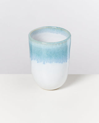 Weiße Keramiktasse mit blauer Glasur am oberen Rand, auf weißem Hintergrund.