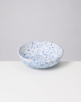 Keramikschale mit blauen Sprenkeln auf einem weißen Hintergrund.