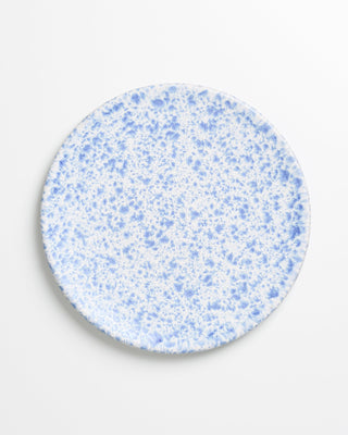 Ein runder Teller mit blau-weißer, gesprenkelter Glasur auf einem weißen Hintergrund.