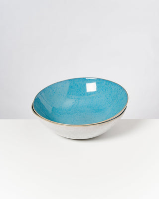 Keramikschale mit blauer Innenseite und weißer Außenseite auf weißem Hintergrund.