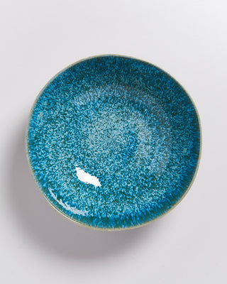 Blaue Keramikschale mit gesprenkeltem Muster und glänzender Oberfläche auf weißem Hintergrund.