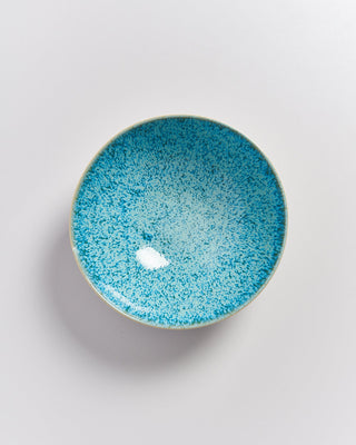 Eine blau gesprenkelte Keramikschale auf weißem Hintergrund.