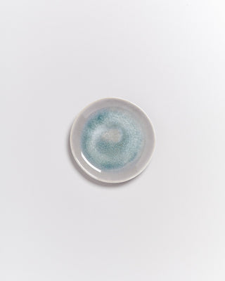 Kleiner Keramikteller mit blau-grüner Glasur auf weißem Hintergrund.