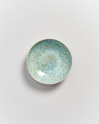 Kleiner Teller mit blauer und grüner Sprenkelmusterung auf weißem Hintergrund.