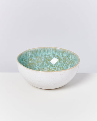 Weiße Schale mit grün-blauem Innendesign auf einem weißen Hintergrund.