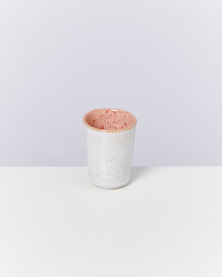 Keramikbecher mit weißer Außenseite und rosa gesprenkelter Innenseite auf weißem Hintergrund.