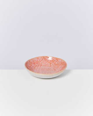 Orangefarbene Keramikschale mit gesprenkeltem Muster auf weißem Hintergrund.