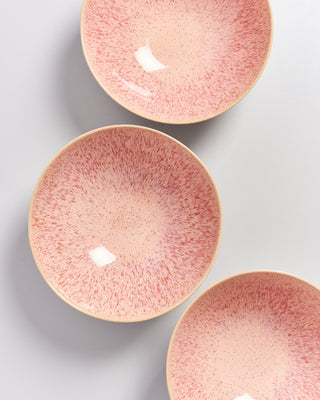 Drei rosa gesprenkelte Keramikschalen liegen auf einer weißen Oberfläche.