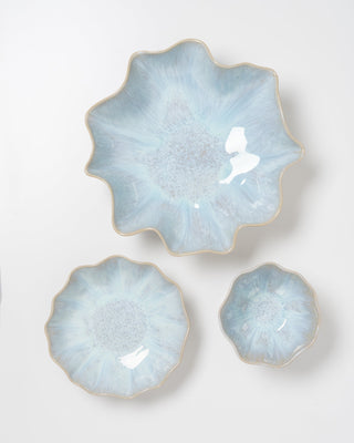 Drei blumenförmige, blaue Schalen in verschiedenen Größen auf weißem Hintergrund.