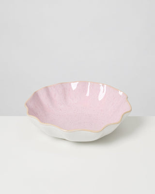 Rosa, schalenförmige, gewellte Keramikschüssel mit cremefarbenem Rand auf weißem Hintergrund.