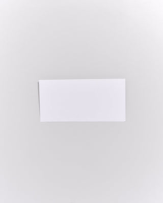 Ein weißer Umschlag liegt auf einer neutralen, hellgrauen Fläche.