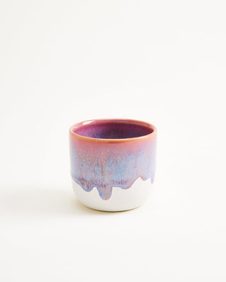 Keramikbecher mit fließendem Farbverlauf in Rosa und Blau auf weißem Hintergrund.