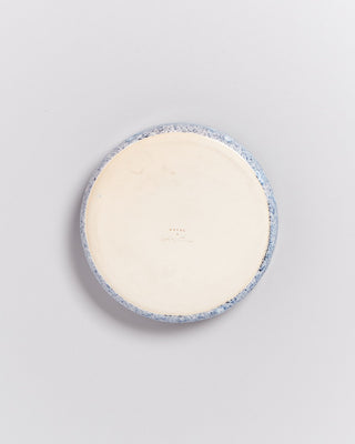 Runde, flache Keramikschale mit blauer und weißer Marmorierung, von oben betrachtet.
