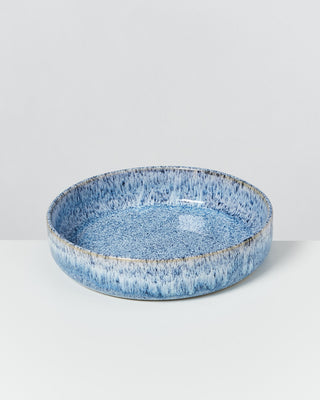 Blaue Keramikschale mit gesprenkeltem Muster auf weißem Hintergrund.