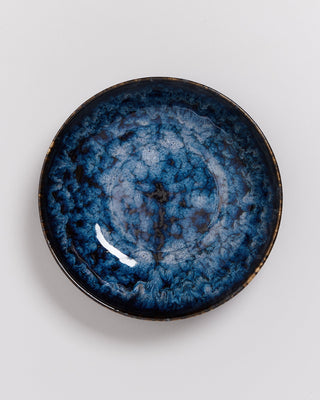 Blaue Keramikschale mit einem marmorierten Muster auf weißem Hintergrund.