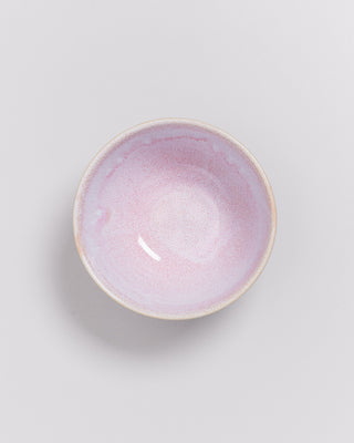 Runde, pastellrosa Keramikschale auf weißem Hintergrund.
