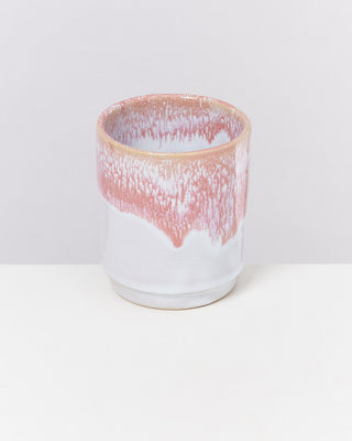 Keramikbecher mit weißer und rosa glasierter Oberfläche auf hellem Hintergrund.