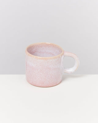 Rosa Keramiktasse mit Henkel auf weißem Hintergrund.
