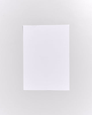 Ein weißes Blatt Papier liegt auf einem grauen Hintergrund.