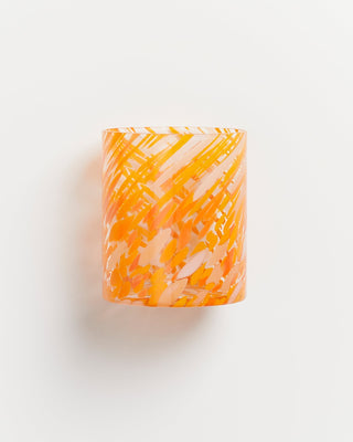 Orange-weiß gemusterter Glasbecher mit wirbelnden Streifen auf weißem Hintergrund.