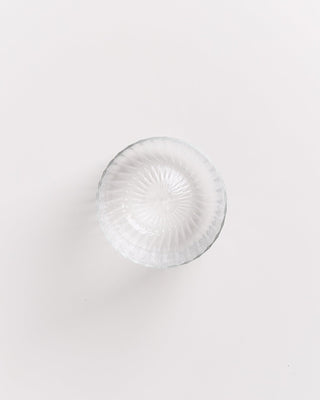 Obenansicht einer leeren, geriffelten Glasschale auf weißem Hintergrund.