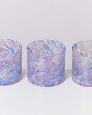 Drei bunte Gläser mit violetten und blauen Mustern auf weißem Hintergrund.