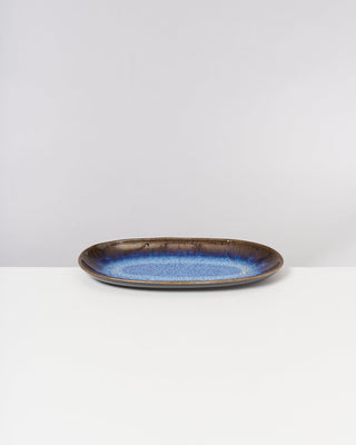 Blauer und brauner Keramikteller auf weißem Hintergrund.