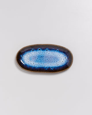 Ovale Keramikschale mit blauem, gesprenkeltem Muster auf hellem Hintergrund.