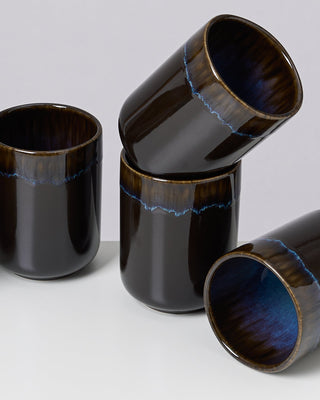 Vier schwarze, glänzende Keramikbecher mit blauer Innenseite und blauem Rand, teils übereinander gestapelt.