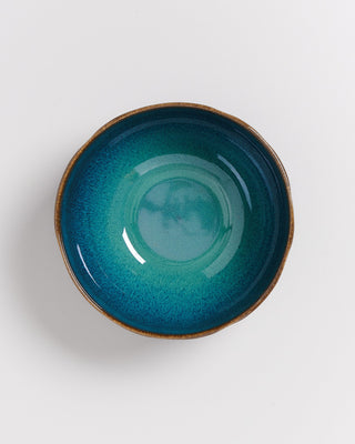 Keramikschale mit blauer Glasur und braunem Rand auf weißem Hintergrund.