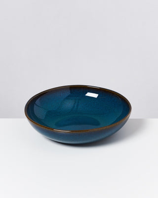 Eine dunkelblaue, runde Keramikschale mit glasiertem Finish auf weißem Hintergrund.