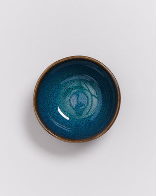 Blau-braune Keramikschale mit glatter Glasur auf weißem Hintergrund.