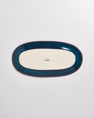 Ovaler Teller mit blauem Rand, von oben fotografiert, mit Logo in der Mitte auf der Unterseite.