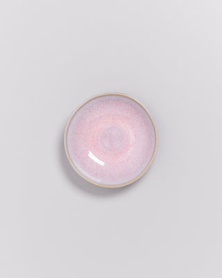 Keramikteller mit rosa Farbverlauf auf grauem Hintergrund.
