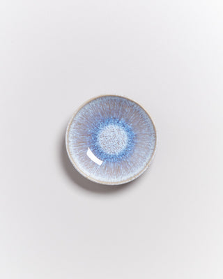 Kleine runde Keramikschale mit blau-weißem, radialem Muster auf hellem Hintergrund.