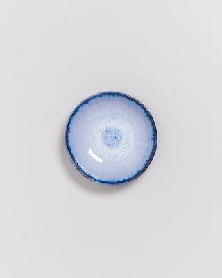 Kleine, runde, blau-weiße Keramikschale mit einem kunstvollen, strahlenförmigen Muster auf der Innenfläche.