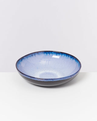 Blau-weiße Keramikschale mit dunklem Rand auf weißem Hintergrund.