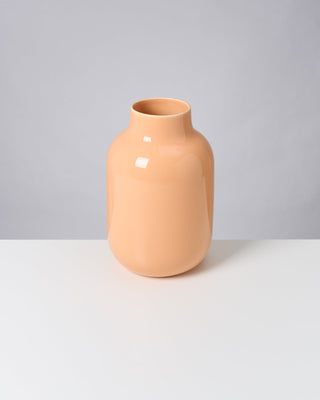 Beige Vase auf weißem Tisch vor grauem Hintergrund.