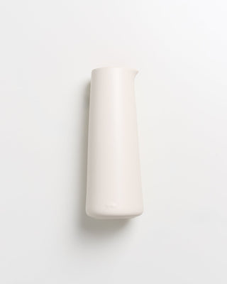 Weiße, schlanke Vase auf weißem Hintergrund.