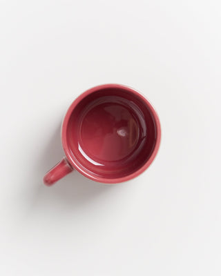 Rote Tasse von oben auf weißem Hintergrund fotografiert.
