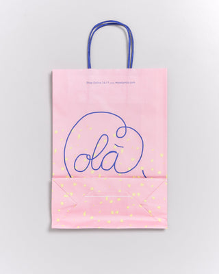 Eine rosa Einkaufstüte mit blauen Henkeln und der Aufschrift "olá" in Blau.