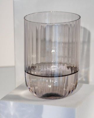 Ein durchsichtiges, geriffeltes Glas steht auf einem weißen Podest.